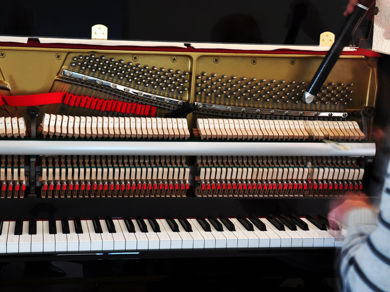 Technician tuning a piano
